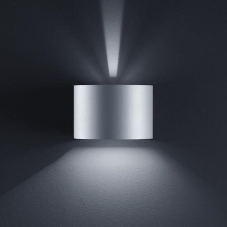 LED Außen-Wandleuchte Siri 44 - R IP54 Silbergrau an einer Wand mit sanfter Beleuchtung.
