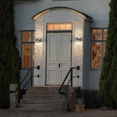 Hild LED Udendørs væglampe oplyser indgangspartiet i et hus med matteret glas og varmt lys.