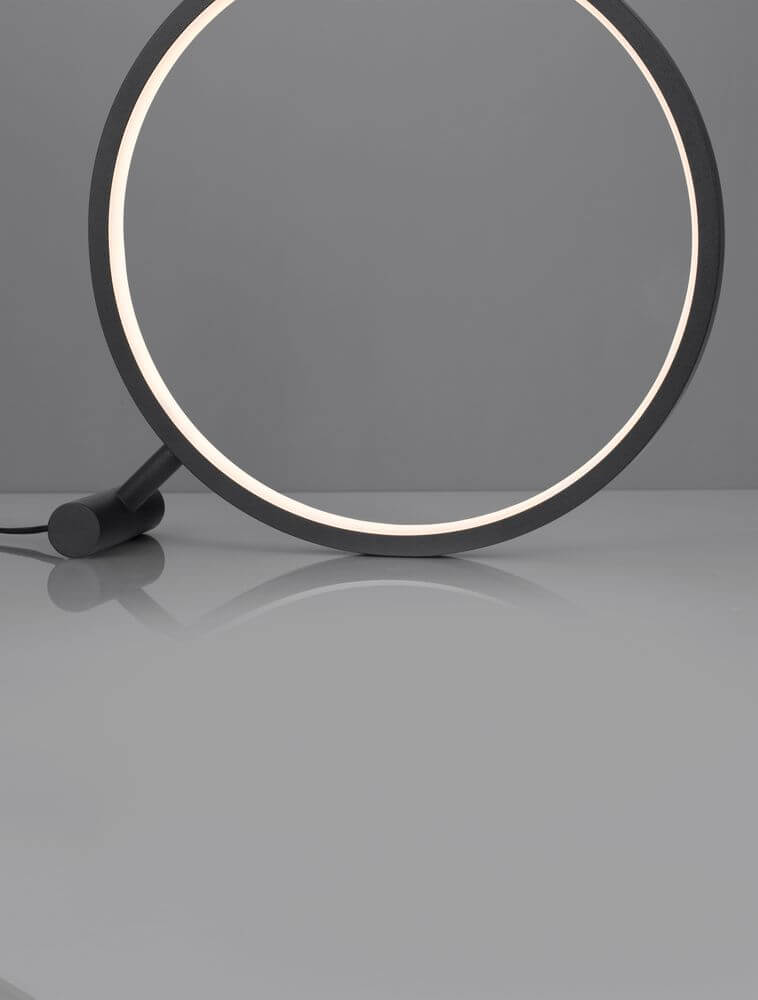 Hola LED Tischleuchte 3000K Schwarz auf einem modernen Tisch, elegantes Design mit runder Form.
