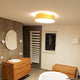 Holz-Deckenleuchte Discus Deutsche Eiche in modernem Badezimmer mit warmem Licht.