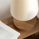 Holz Tischlampe mit zylindrischem Schirm auf Holzunterlage, modernes Design und natürliche Materialien.