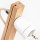 Detailansicht einer Holz Tischlampe mit zylindrischem Schirm und hellem Holzgestell.