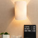 Holz Wandlampe mit Schirm geschwungen an der Wand, strahlt warmes Licht aus.