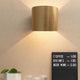 Holz Wandleuchte mit Schirm Zylindrisch in goldfarbigem Design, Betonwand und Preisliste im Hintergrund.