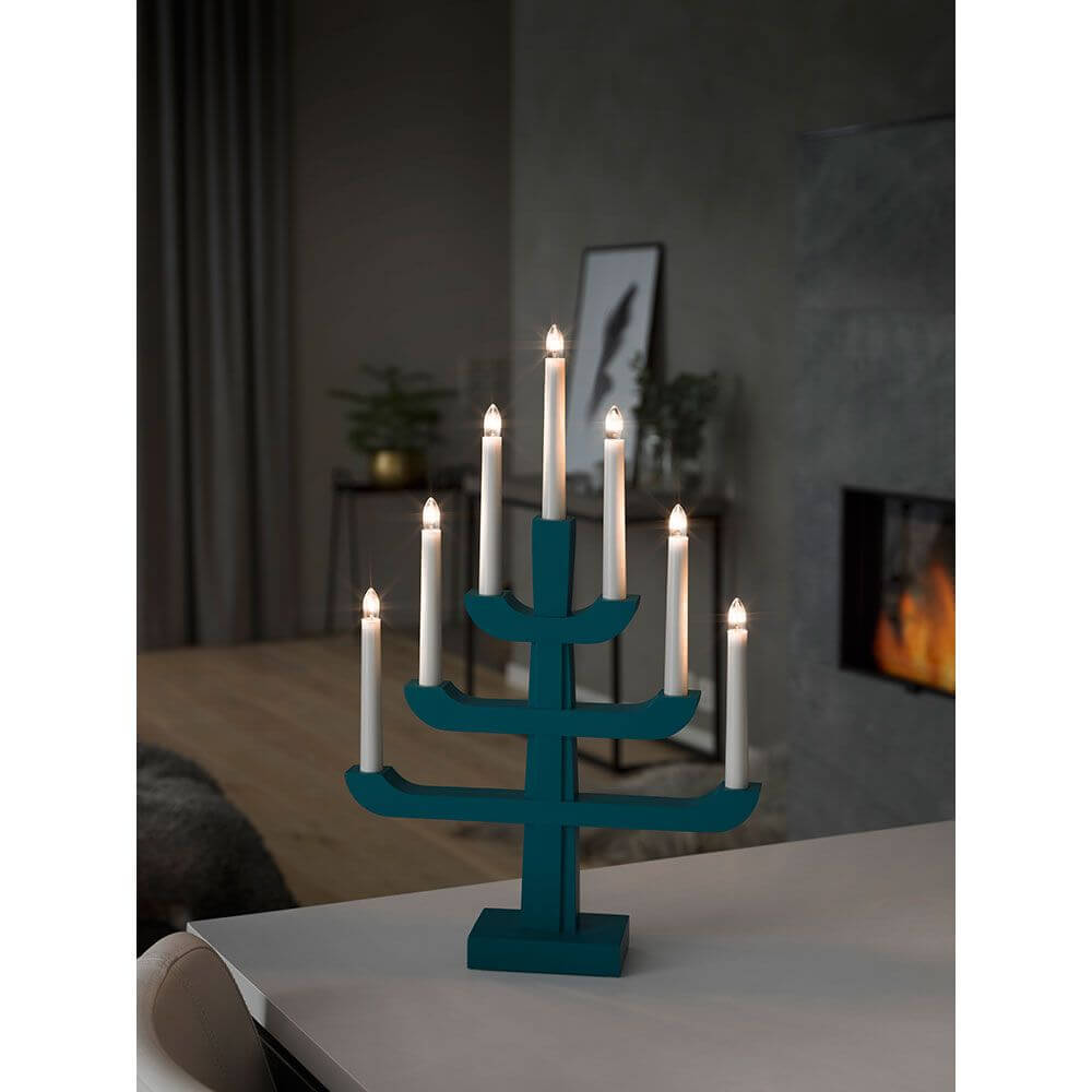 Holzleuchter blau/grau lackiert 7 klare Birnen auf einem Tisch in einem stilvollen Wohnambiente.