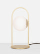 Hook LED Tischleuchte 3000K Gold-Gebürstet, Weiß auf einem Tisch, modernes Design mit Glas und Metall.