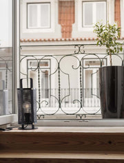 Ian table lamp in black on a windowsill, combined with modern design elements.