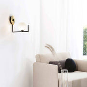Birds Wandleuchte in modernem Wohnraum mit goldener Wandhalterung und opaler Kugellampe