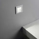 Moderne Bit LED Wand-Einbauleuchte in elegantem Design, montiert an grauer Wand neben weißer Fläche.