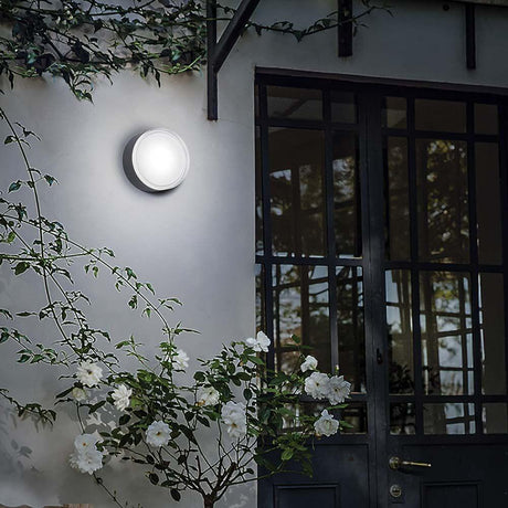 Taklampe Urano Pl1 Gross Antrasitt på veggen med blomster og dører i bakgrunnen.