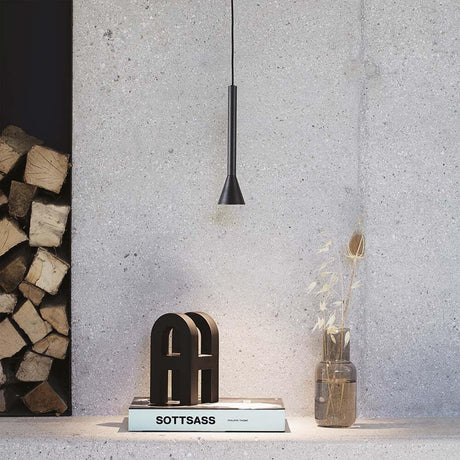 Moderne Diesis LED Pendelleuchte über einem stilvollen Tischarrangement in minimalistischer Umgebung.