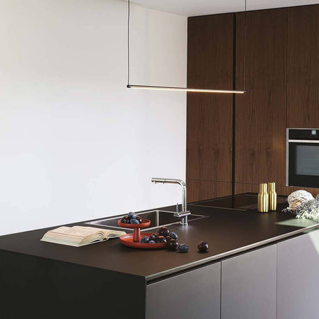 Essence LED pendant light above a modern kitchen island with stylish decor.