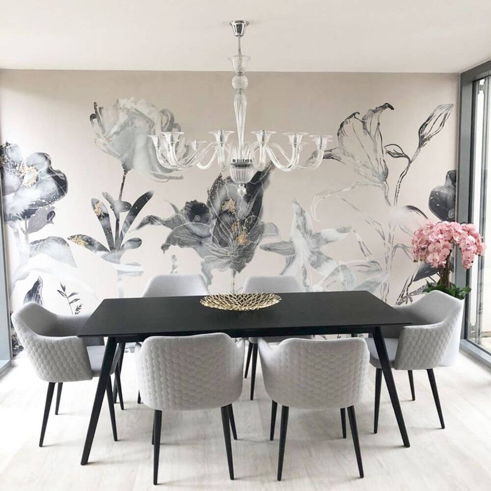 Hängeleuchte Brigitta 12-flammig Transparent, Chrom über einem eleganten Esstisch mit Blumenwandtapete.