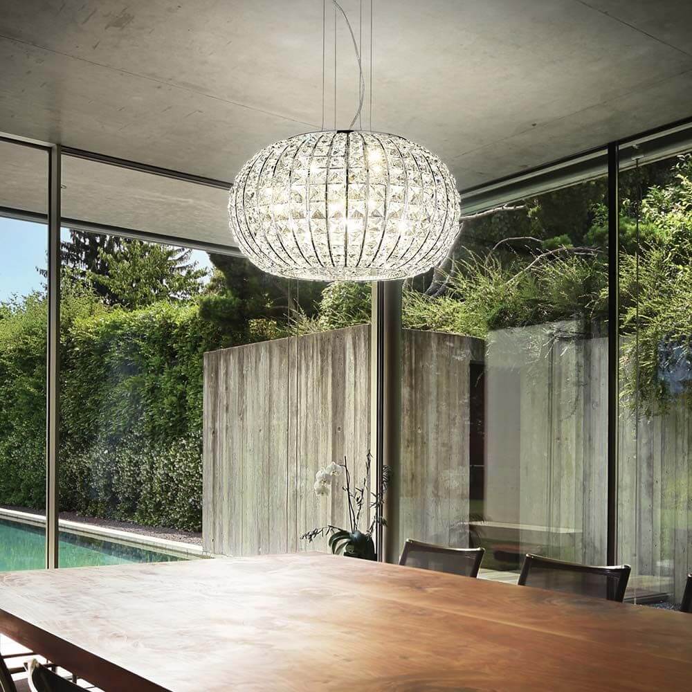 Hängeleuchte Calypso Sp5 mit modernem Design, schwebend über einem Tisch in einem eleganten Raum.