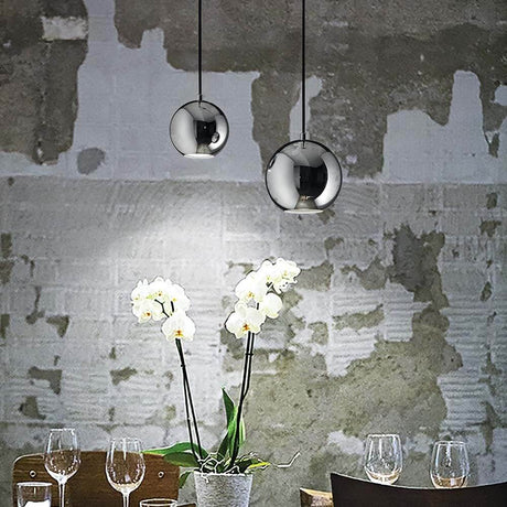 Hängeleuchte Mr Jack Sp1 Gross Chrom über einem Tisch mit Orchideen und Weingläsern.
