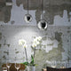 Hängeleuchte Mr Jack Sp1 Gross Chrom über einem Tisch mit Orchideen und Weingläsern.