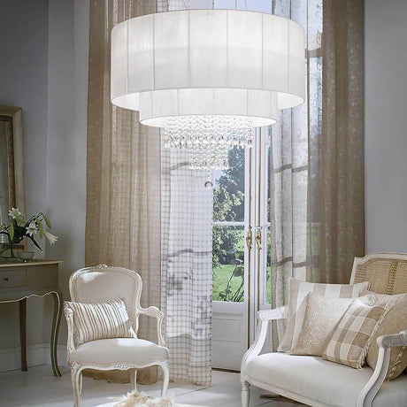 Opera Sp10 hvidt hængelys i den elegante stue med moderne møbler og stilfulde gardiner.