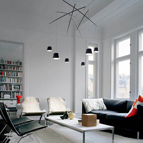 LED Pendelleuchte Fish 6-flg. Schwarz in modernem Wohnzimmer mit stilvollen Möbeln und Bücherregal.