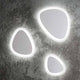 LED Wandleuchte Gingle Mittel Weiß auf grauer Wand mit einzigartigem Design in verschiedenen Formen.
