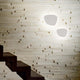 Peggy LED Wandlampe Weiß an einer stilvollen Wand mit Treppe im Hintergrund