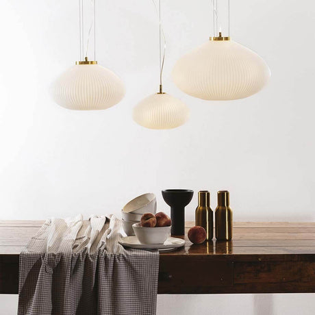 Stilvolle Plisse Pendelleuchte über einem Holztisch mit Geschirr und Deko, ideal für modernes Wohnen.