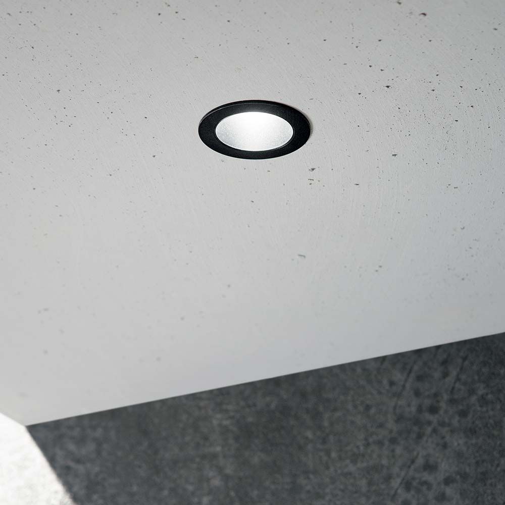 Quark LED Einbauleuchte Spot in schwarzem Rahmen, installiert in einer Decke aus Beton.