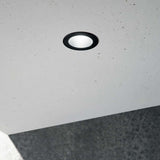 Quark LED Einbauleuchte Spot in schwarzem Rahmen, installiert in einer Decke aus Beton.