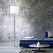 Lampe sur pied Set Up élégante à côté d’un canapé bleu dans un salon moderne avec mur gris.