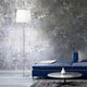Stylische Set Up Stehleuchte neben einem blauen Sofa in modernem Wohnzimmer mit grauer Wand.