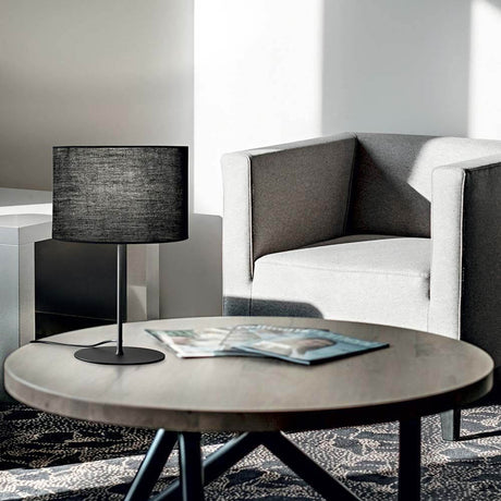 Set Up table lamp on a table next to a grey armchair in a modern room.