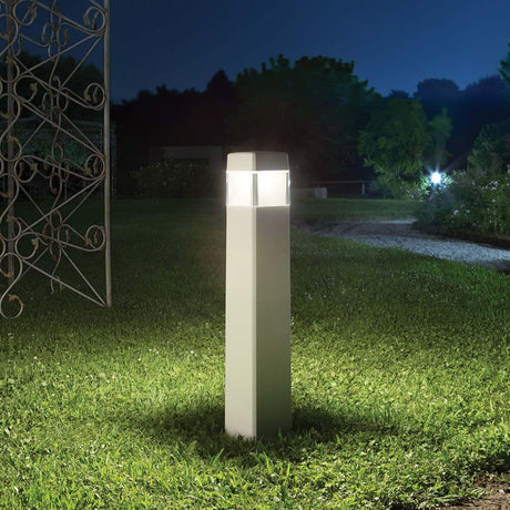 Floor lamp Elisa Pt1 Gross White in the garden at night, illuminated and modernly designed.