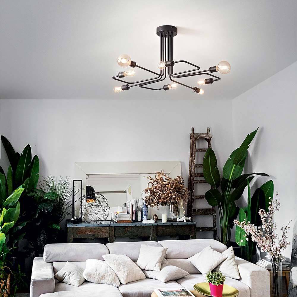 Triumph Deckenleuchte 8-flammig Schwarz in einem modernen Wohnzimmer mit Pflanzen und einer gemütlichen Couch.