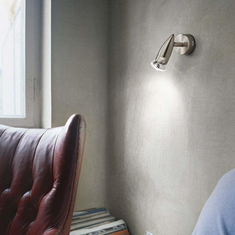 Wall light Alfa Ap1 Burnished on a wall above a red armchair, modern and stylish.