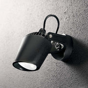 Applique murale Minitommy Ap1 noire montée sur un mur, source lumineuse élégante pour votre intérieur.