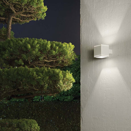 Wall light Snif Square Ap1 White on the wall illuminates the garden with gentle beams of light.