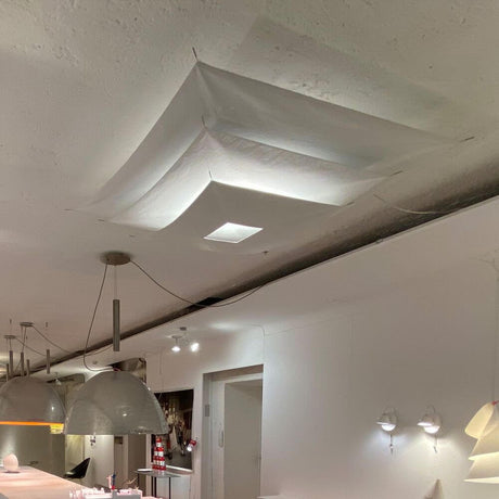 Ingo Maurer LED Plafonnier Lil Luxury, luminaire de plafond moderne avec des voiles dorées flottant dans l’espace.