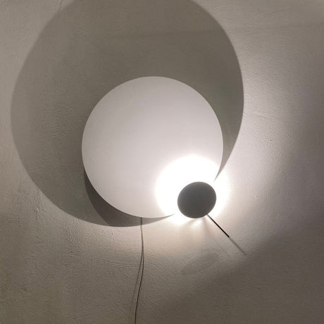 Ingo Maurer LED Wandlampe Eclipse Ellipse Ø 60cm mit besonderen Licht- und Schattenspielen an der Wand.
