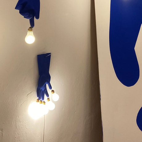 Ingo Maurer LED Applique murale Luzy On The Wall gant en caoutchouc bleu avec des ampoules au bout des doigts.