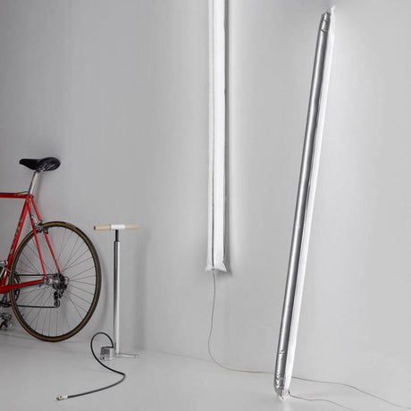 Ingo Maurer Steckernetzteil für Blow Me Up Stehleuchte und Fahrradpumpe in modernem Raum.