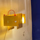 Ingo Maurer 24 Karat Blau Wandlampe mit goldenen Blenden und warmem Licht an einer Wand.