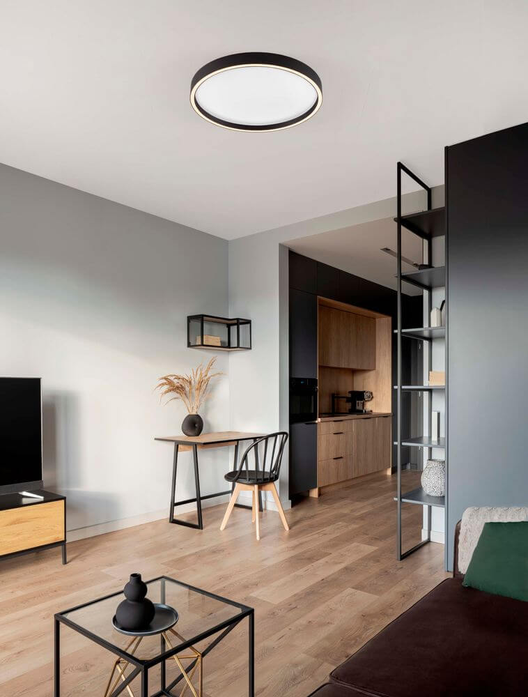 Moderne Istos Deckenleuchte Ø 50cm in einem stilvollen Wohnzimmer mit Holzfußboden.