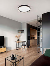 Moderne Istos Deckenleuchte Ø 50cm in einem stilvollen Wohnzimmer mit Holzfußboden.
