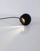 Joya LED Außenwandeinbauleuchte Up 3000K Schwarz IP65 auf einem Tisch mit Lichtstrahl.