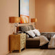 Tischleuchte Face Wire Orange auf Nachttischen in modernem Schlafzimmer mit warmen Farben.
