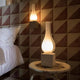 Karman Amarcord Tischlampe auf einem Tisch neben einem Bett in einem modernen Wohnraum.
