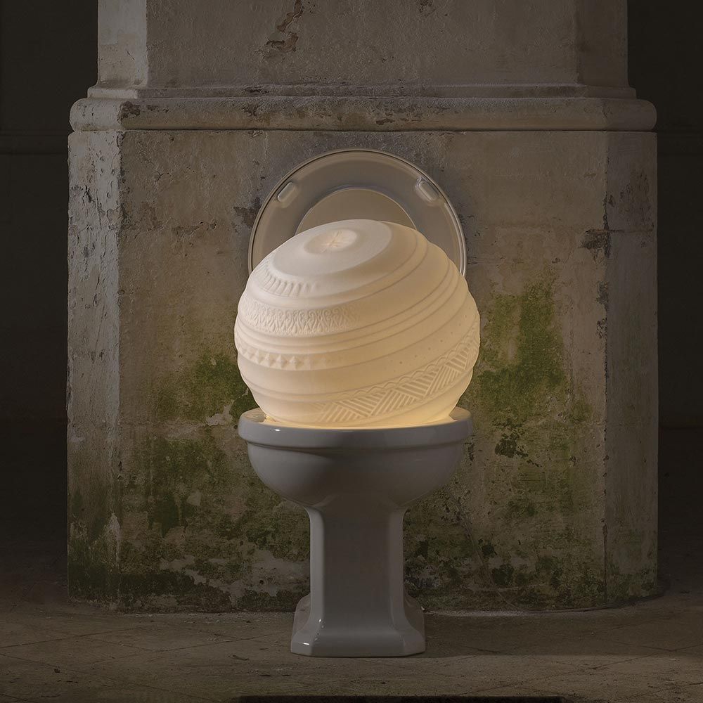 Designer Lichtobjekt in Form einer Kugel auf einer Toilettenanlage, leuchtet sanft und kreativ.