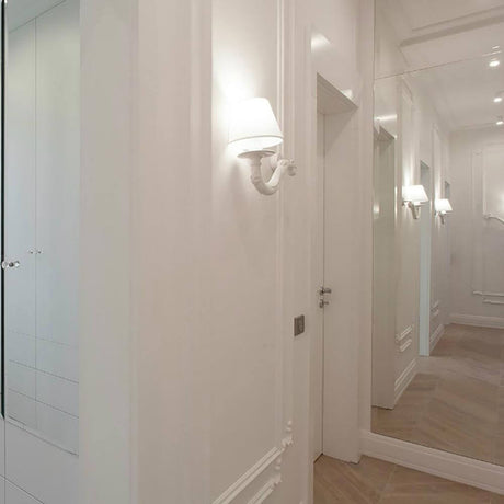 Élégante applique Karman Deja-Vu dans un couloir clair et rustique avec un grand miroir.
