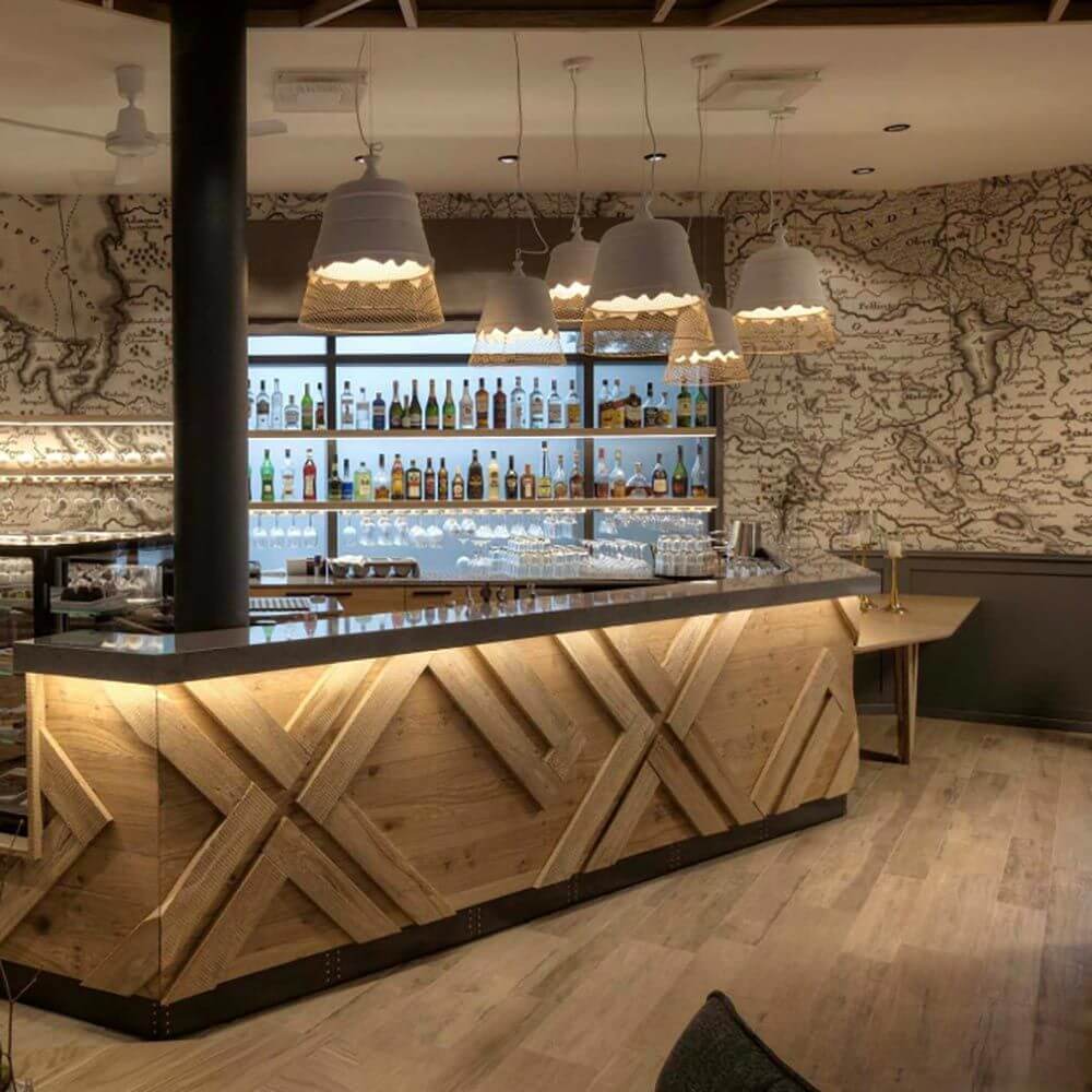 Karman Domenica Hängeleuchte aus Gips & Metall über elegante Holzbar in modernem Restaurant.