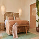 Karman Kimono Hängeleuchte über einem stilvollen Bett in hellen, eleganten Schlafzimmer mit Naturdekor.