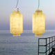 Karman Kimono LED Außen-Hängeleuchte IP65 im sanften Licht über Wasser bei Sonnenuntergang.